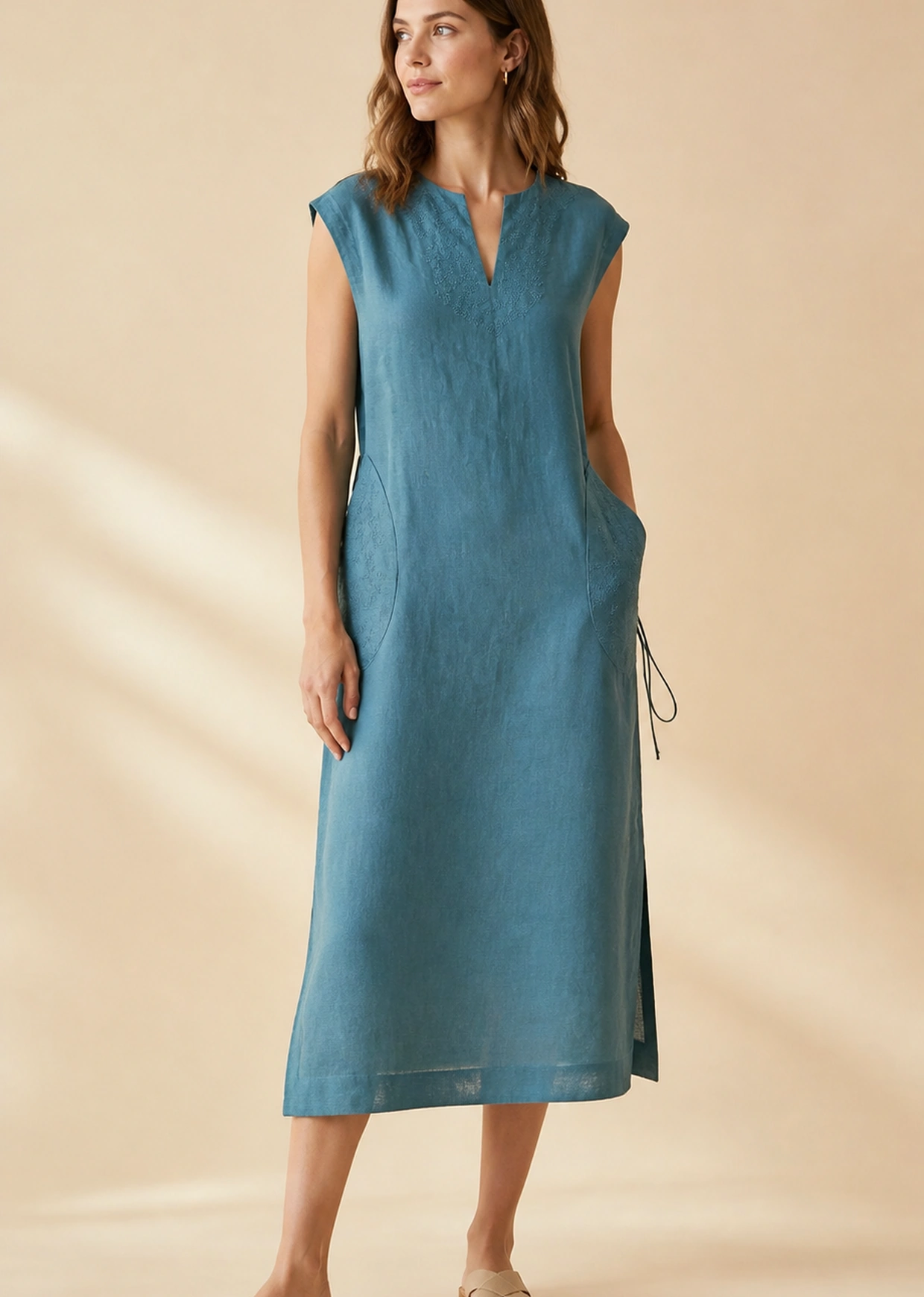 Woman wearing a turquoise-green sleeveless fluid dress