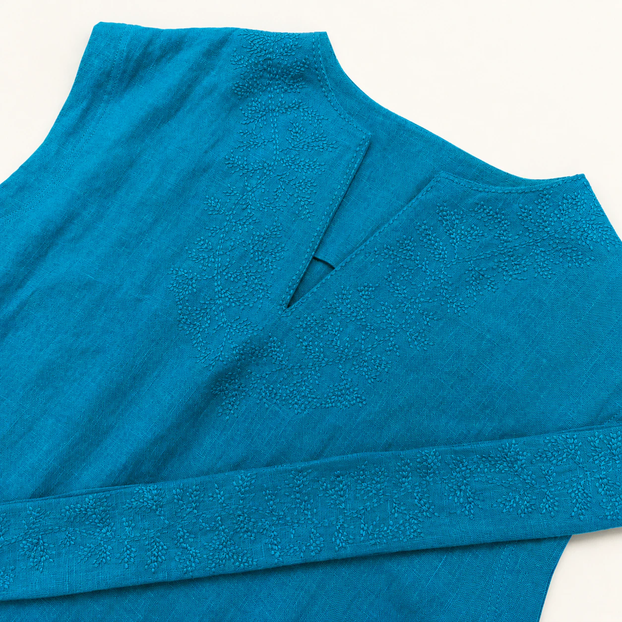 Lower section of the turquoise-green dress showing the hem and side opening
