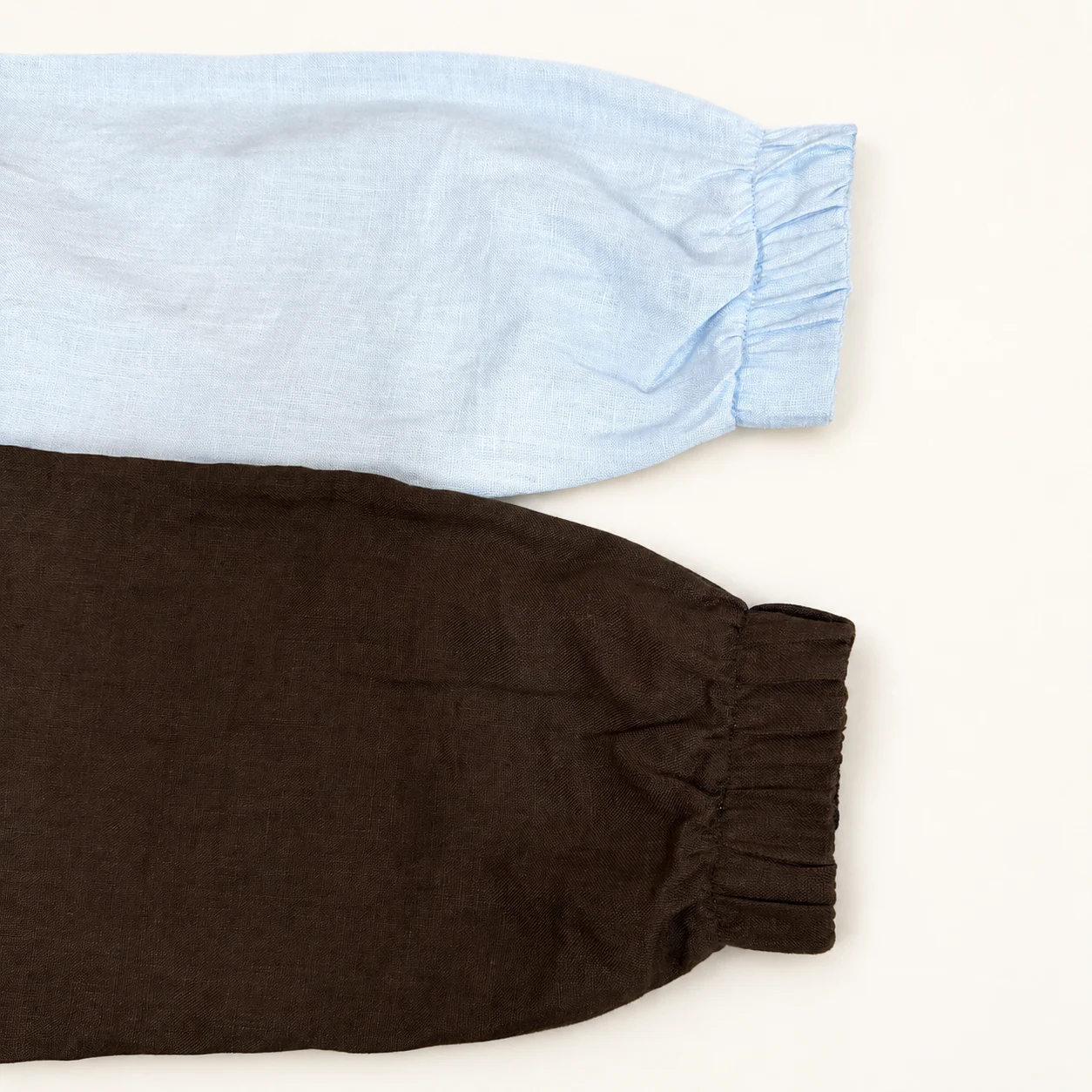 Shell-blue and brown ribbed bomber cuffs laid side by side